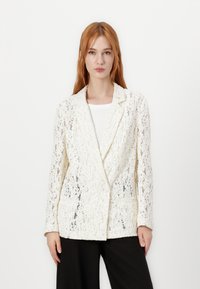 White lace blazer with a textured pattern, tailored design, notched lapels, and two front pockets, paired with a simple white top.