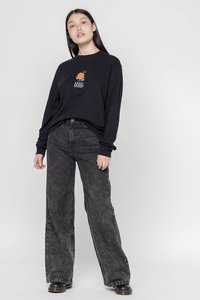 T-shirt nero a maniche lunghe con una grafica a fumetto arancione. Abbinato a jeans neri larghi e sbiaditi e stivali neri.