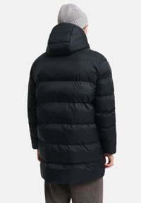 Sort pufferjakke med quiltet design, der har hætte og lange ærmer. Stoffet har en glat tekstur, der giver varme og komfort.