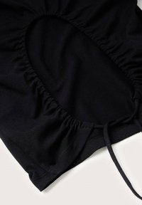 Zwart hoeslaken met elastische randen en een aantrekkoord op een witte ondergrond.