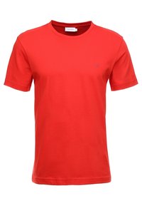 Jednoduché červené tričko s krátkým rukávem značky Calvin Klein s kulatým výstřihem a malým logem "CK" na levé hrudi.