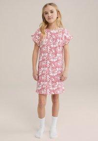 Roza bombažna obleka s kratkimi volanastimi rokavi, ki ima bel cvetlični in živalski vzorec. Nosi se nad belimi gležnjačami.