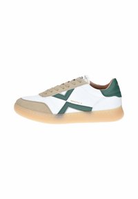 Sneaker bianco con accenti verdi, lacci beige e una suola arrotondata color gomma. Presenta una texture in pelle liscia e camoscio con un design geometrico.