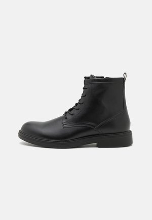 Stivaletto nero in pelle con lacci, linguetta, punta tonda e suola piatta, mostrato di profilo su sfondo bianco.
