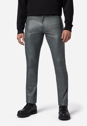 Grijze leren broek met een gladde textuur, slim fit en minimale stiksels. Draag het met zwarte veterschoenen.