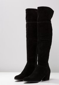 Stivali over-the-knee in suede nera con tacco quadrato, dotati di zip laterali e dettagli di cucitura discreti sulla parte superiore.