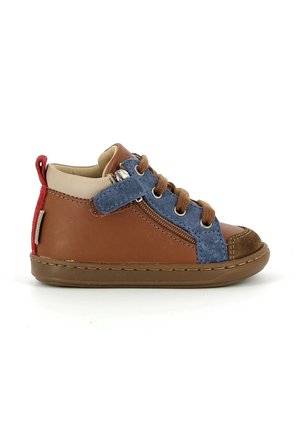 Chaussure marron pour tout-petit avec zone de lacets en daim bleu, lacets marron, fermeture éclair latérale et languette rouge au talon sur fond blanc.