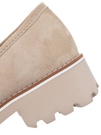 Beige suede shoe with thick, ridged sole, brown and white trim, and visible stitching along the upper edge.