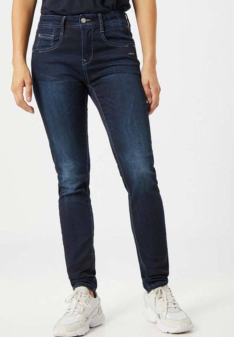 Dunkelblaue Denim-Jeans mit schmaler Passform und mittelhohem Bund, ausgestattet mit Vordertaschen, Kontrastnähten und einem Reißverschluss.