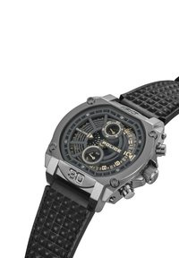 Ura srebrne barve z teksturiranim črnim usnjenim paščkom, okroglim ohišjem, črnim številčnico, zlato obrobo in dvema prikazoma časa. Ima velik številčni znak "30".