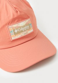 Koral baseball caps med flat brem, med en stofflapp som har et naturskjønt design og Columbia PFG-logoen foran.