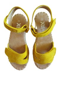 Sandali in suede giallo con cinturini alla caviglia regolabili, punta aperta e dettagli ritagliati. Soletta color marrone chiaro con cuciture a vista.