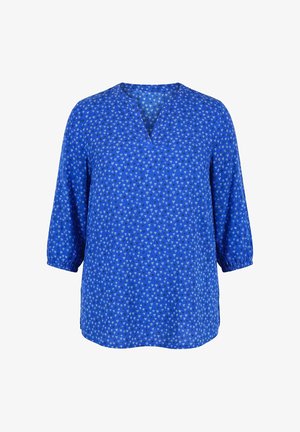 Blusa azul con pequeños estampados de corazones blancos, mangas tres cuartos con puños elásticos y cuello en V.