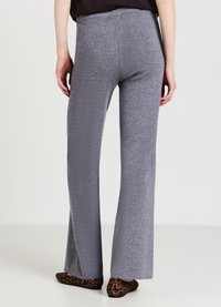 Graue Schlaghosen aus einem strukturierten Stoff, mit einem hohen Taillenbund und einem knöchellangen Schnitt, kombiniert mit Ballerinas im Leopardenmuster.