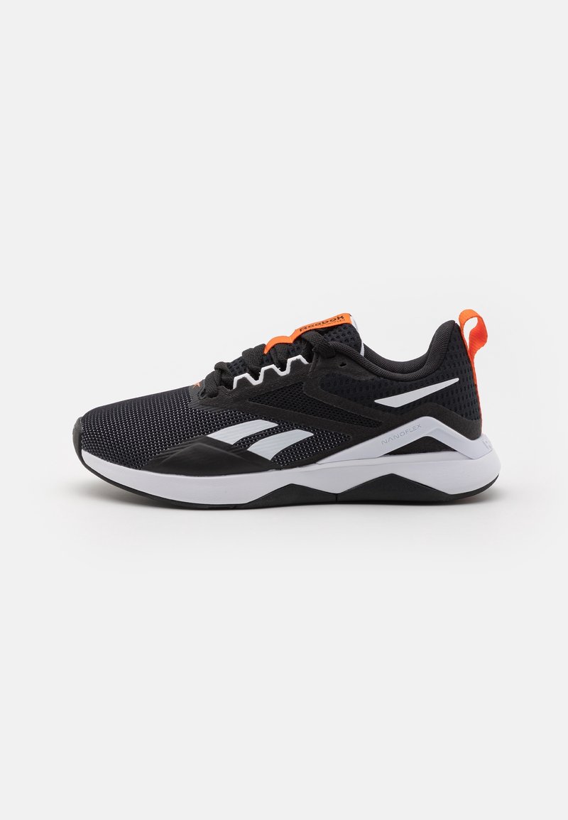Baskets athlétiques noir et blanc avec des accents orange, tige en mesh respirant et semelle blanche amortissante, montrées de côté sur fond blanc.