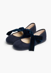 Bailarinas azul marino hechas de suave ante, con punta redonda, tacón bajo y grandes lazos de terciopelo a los lados. Forro interior suave.