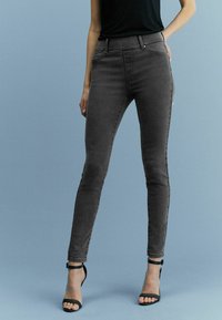 Graue hochgeschnittene Skinny-Jeans aus einem dehnbaren Baumwollmix, mit glatter Textur, subtiler Ausbleichung und Fünf-Taschen-Design.