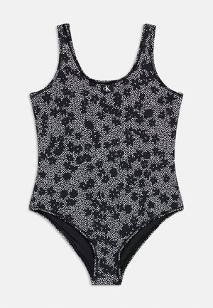 Μαύρο ολόσωμο μαγιό με λευκό πουά λουλουδάτο σχέδιο και λογότυπο CK στο κέντρο του στέρνου.