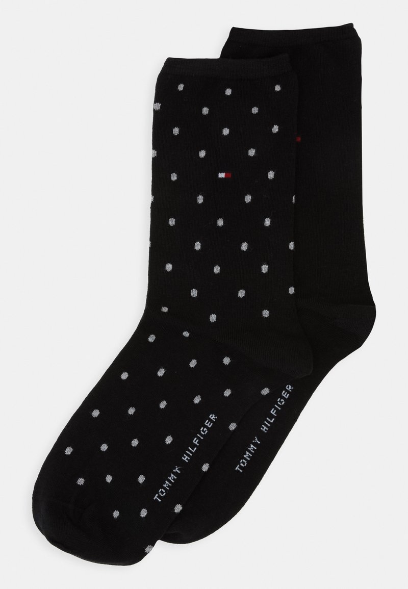 Schwarze Baumwollsocken mit einem gepunkteten Muster in Grau und Weiß. Mit Branding am Bündchen in weißem Text. Weicher Stoff.