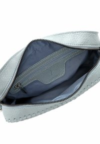 Pochette in pelle azzurra chiara con un esterno strutturato, cerniera argentata e un interno in tessuto blu a contrasto con una tasca con cerniera.