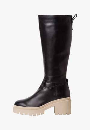 Knee-high zwarte leren laarzen met een dikke beige platformzool en een gestructureerde afwerking. Voorzien van een trekband aan de achterkant voor eenvoudig aan- en uittrekken.