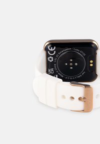 Reloj inteligente con una carátula rectangular negra, acentos dorados y una correa de silicona blanca. La parte trasera cuenta con cuatro sensores y detalles del producto.