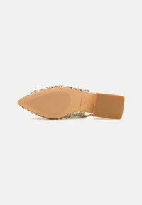 Zapato de punta afilada con parte superior metálica trenzada, tacón de goma marrón claro y suela texturizada. Tamaño 37 indicado en la suela.