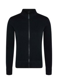 Melnā zip-up jaka ar augstu apkakli, tekstūrētu audumu un garām piedurknēm ar pieguļošu aproci. Iezīme centrāls rāvējslēdzējs un zivs kaulu raksts.