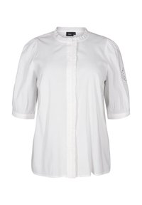 Vit kortärmad blus med rund krage, rynkdetalj framtill och subtila perforerade detaljer på ärmarna. Tillverkad av lättviktsmaterial.