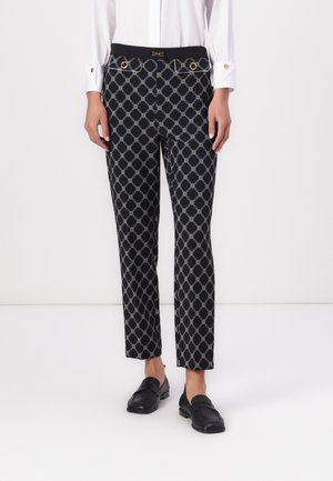 Black patterned trousers featuring a geometric design, gold hardware accents, and a fitted waist with side pockets. Smooth fabric texture.