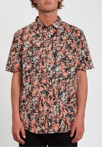 Chemise à manches courtes de couleur corail, avec un motif abstrait noir et blanc ; design à boutons, poche poitrine gauche et tissu texturé.