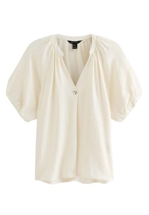 Blusa de manga corta color blanco roto con mangas abullonadas, escote fruncido y cierre frontal con un solo botón decorativo.