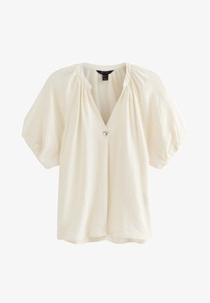 Blusa de manga corta color blanco roto con mangas abullonadas, escote fruncido y cierre frontal con un solo botón decorativo.