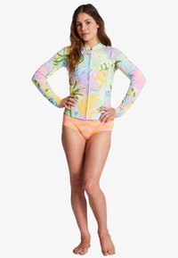Rash guard de manga larga en colores pastel con patrón floral; con cremallera en la parte delantera. Bikini de cintura alta con remolinos en rosa y naranja. Tejido suave y elástico.