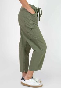 Pantalones cargo verde oliva con cintura ajustable, corte recto, múltiples bolsillos y un ajuste relajado. Fabricados en tejido suave y duradero.
