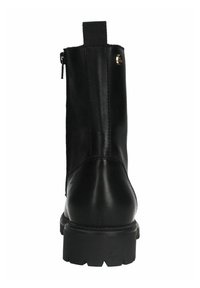 Bottine en cuir noir avec un bout rond, une tige texturée et une semelle épaisse. Elle est dotée d'une languette à l'arrière et d'une fermeture éclair sur le côté.