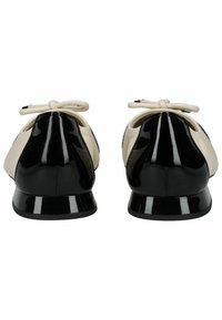 Ballerine con parte anteriore in pelle verniciata beige e tacco verniciato nero, caratterizzate da un piccolo fiocco in cima e una punta arrotondata.