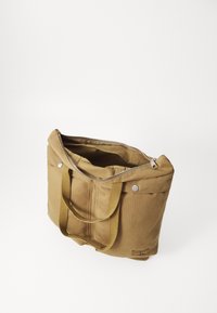 Canvas tote bag i kaki med glidelås, dobbel topphåndtak og sølvfarget hardware. Har et romslig interiør med myk fôring.
