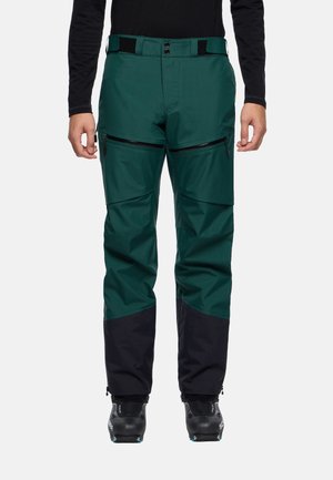 Groene en zwarte waterdichte skibroek met een textuurstof, ritszakken en een verstelbare tailleband. Versterkte onderbenen voor duurzaamheid.