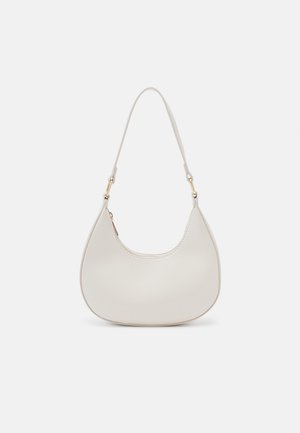 Sac épaule en cuir crème en forme de croissant, avec une fine sangle et des détails de coutures subtils. Design minimaliste avec des accents en métal doré.