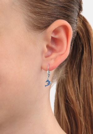 Silberne Creolen mit einem blauen Delfinanhänger, der eine glatte Oberfläche und polierte Akzente aufweist, die direkt unter dem Ohrläppchen hängen.