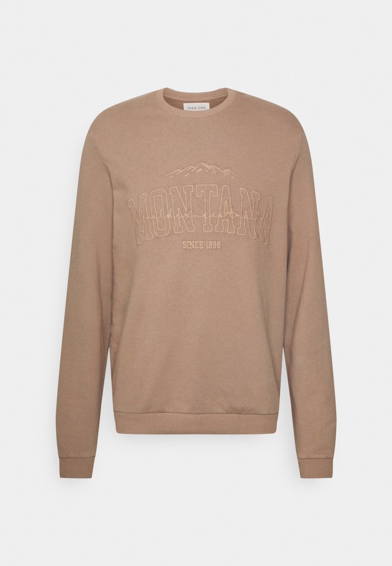 Sweat-shirt beige col rond à manches longues, avec le texte brodé "MONTANA", un motif de montagne et "Since 1986" sur la poitrine.
