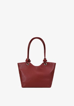 Bolso tote tejido de cuero rojo con asas dobles anudadas y ojales metálicos plateados sobre fondo blanco.