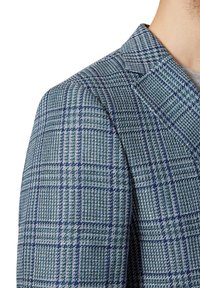 Marynarka w kraciasty wzór w odcieniach zieleni i niebieskiego, wykonana z teksturowanej tkaniny i dopasowanego kroju. Wyróżnia się wyraźnymi klapami oraz drobnymi detalami.