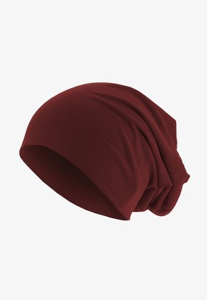 Piros laza beanie, puha anyagból készült, sima textúrával, laza fazonnal, és a hátsó részen összegyűjtött kialakítással a nagyobb térfogat érdekében.