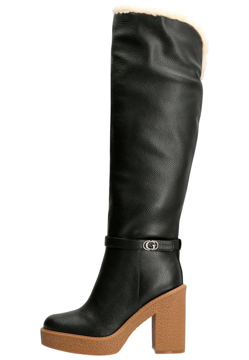 Botte noire en cuir montant jusqu'au genou avec une doublure beige en peluche, une semelle plateforme épaisse couleur tan, et un accent logo argenté sur la bride de la cheville.