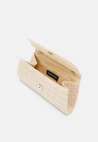 Pochette rectangulaire beige texturée avec une fermeture à bouton-pression et un intérieur en tissu beige comprenant une petite poche et une étiquette de marque.