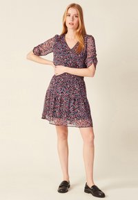 Kleid mit Blumenmuster, V-Ausschnitt, kurzen Puffärmeln und gestuftem Volantsaum, in dunkelblau mit mehrfarbigen Blumen; leichtes, transparentes Material.