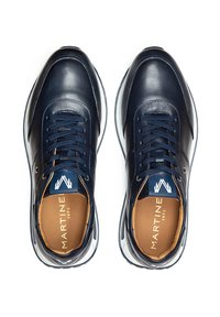 Navyblaue Ledersneaker mit runder Spitze, weißer Sohle, kontrastierenden blauen Schnürsenkeln und geprägter Lasche mit "MARTINE 1973" in Gold. Standarddesign.