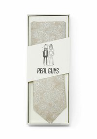 Beige paisley stropdas in een geschenkdoos, met een gestructureerde stof, scherpe snit, en een witte band met een illustratie van een cartoonkoppel en de tekst "ECHTE JONGENS".